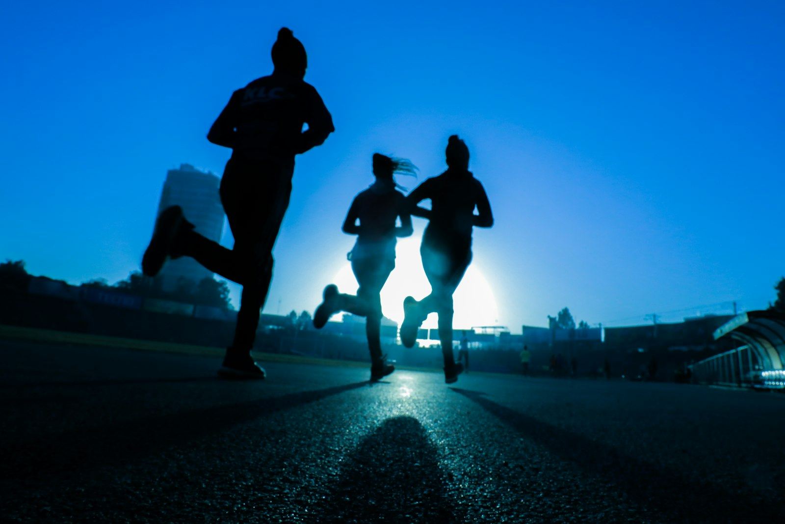 Runners silhouetted at dusk